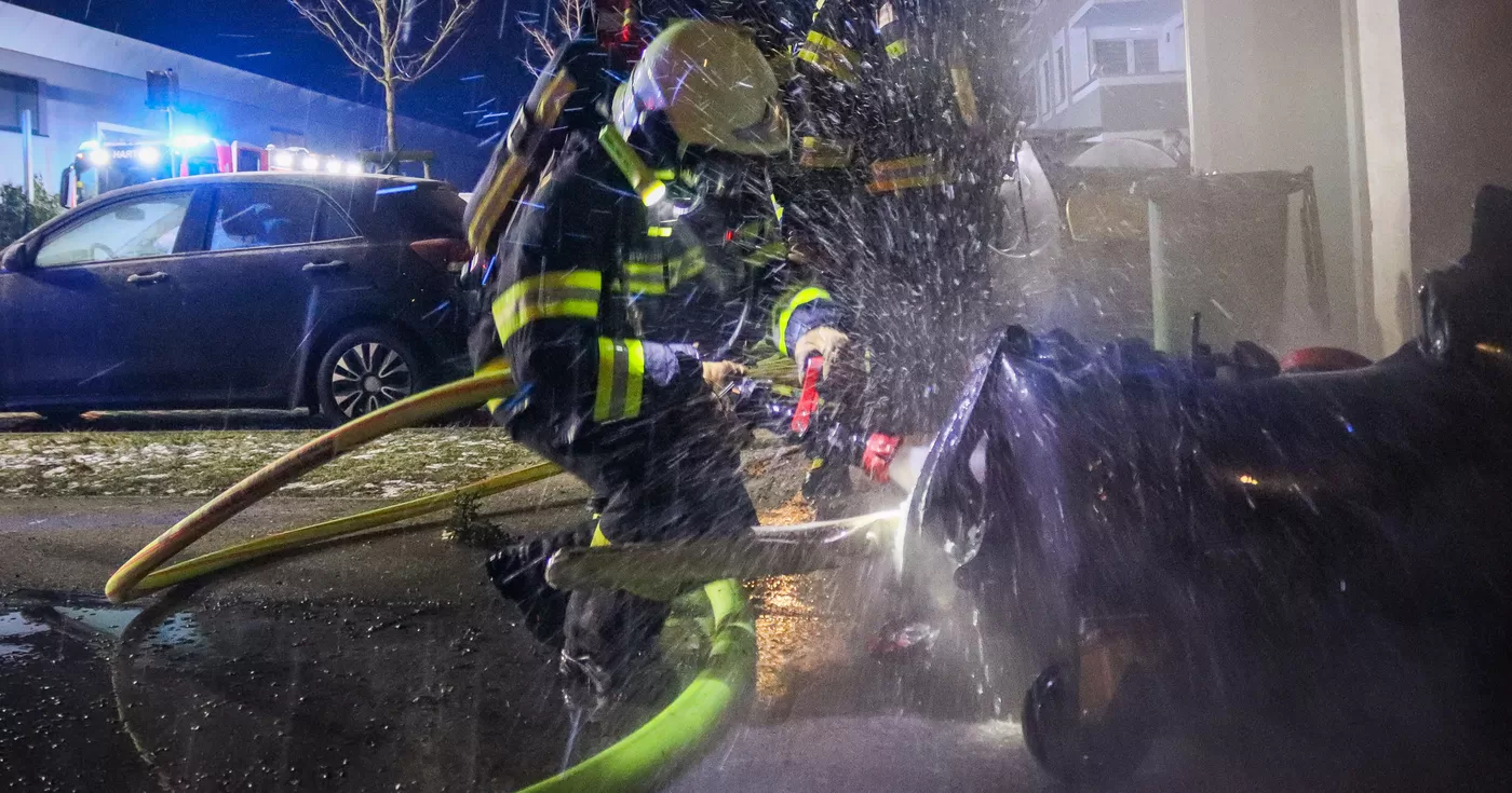 Titelbild: Feuerwehr löscht Containerbrand in Mehrfamilienhaus