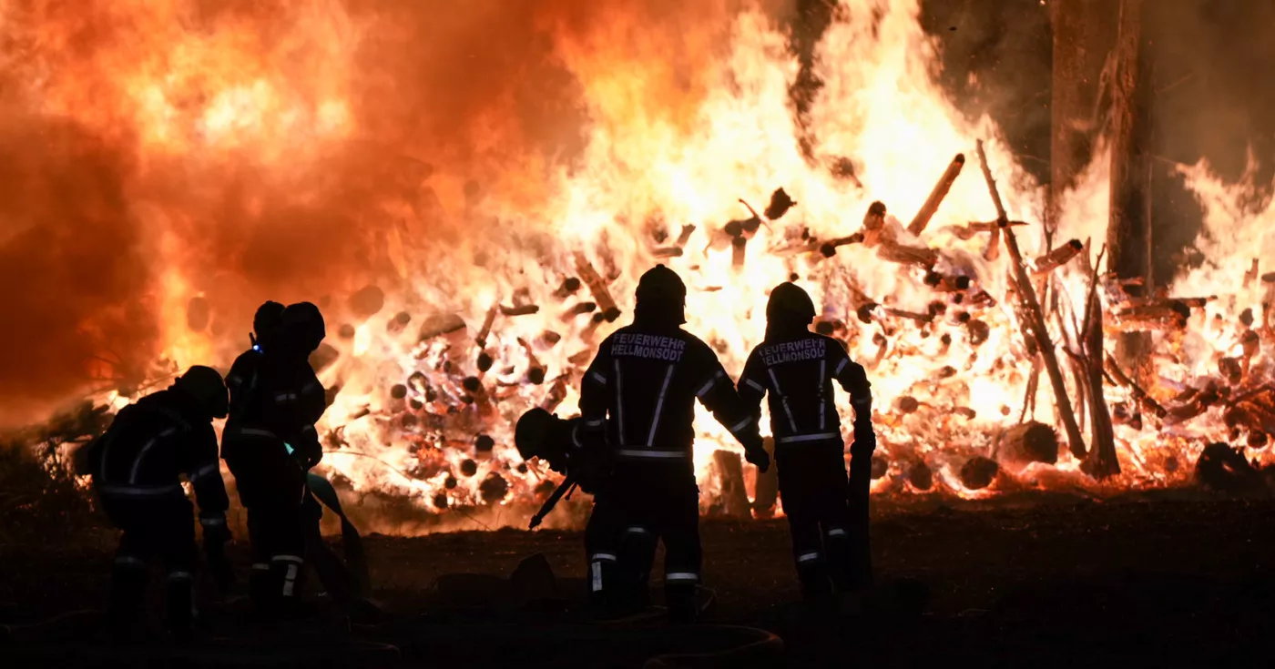 Zwei brennende Holzstöße fordern 11 Feuerwehren